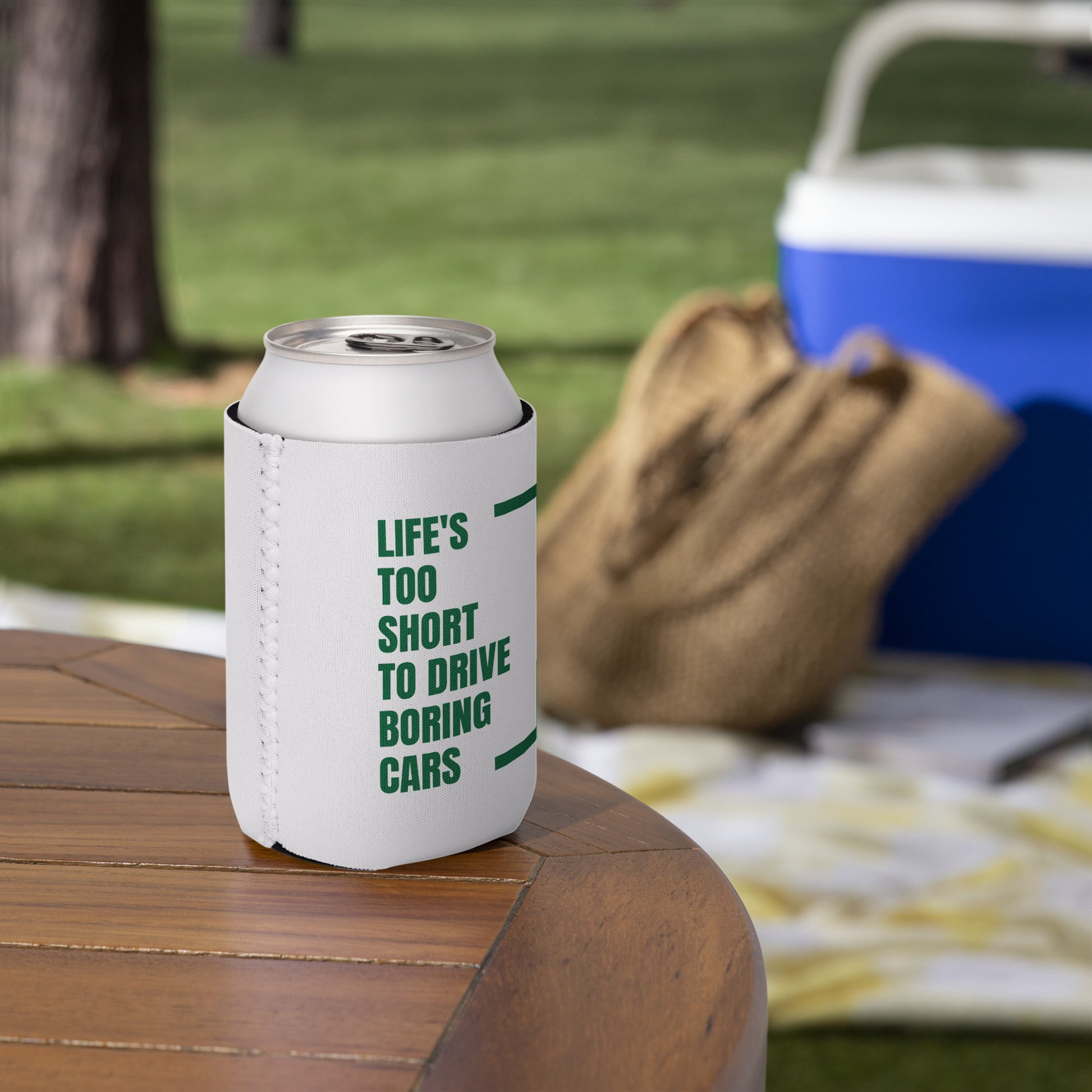 White can cooler with green text on a wooden table outdoors